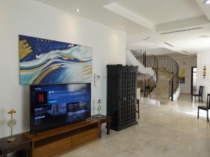 a lobby with a tv and a painting on the wall at Stay House in Dubai in Dubai