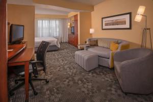 a hotel room with a desk and a bedroom at Courtyard Fredericksburg Historic District in Fredericksburg