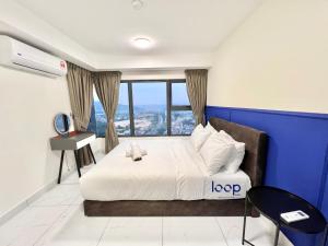 吉隆坡的住宿－Arte Cheras Kuala Lumpur by Loop Suites，一间卧室设有一张蓝色墙壁的大床