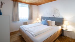 a bedroom with a large white bed with two lamps at Ferienpark Scheiber in Unterburg am Klopeiner See