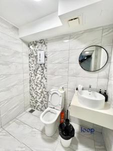 吉隆坡的住宿－Arte Cheras Kuala Lumpur by Loop Suites，一间带卫生间、水槽和镜子的浴室