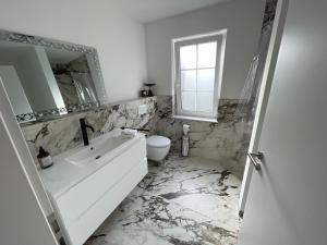 a white bathroom with a sink and a toilet at Gemütliche Wohnung im Herzen von Schwäbisch Gmünd in Schwäbisch Gmünd