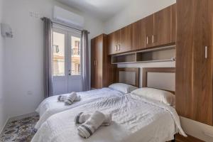1 dormitorio con 2 camas y toallas. en Town House in the Heart of Luqa - close to Malta International Airport en Luqa