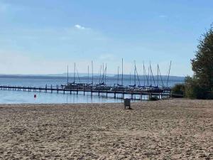 a beach with boats in the water and a dock at Sea Lodge Mardorf in Neustadt am Rübenberge