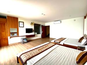sypialnia z 2 łóżkami i telewizorem z płaskim ekranem w obiekcie Hottel HÙNG PHƯƠNG cô tô w mieście Đảo Cô Tô