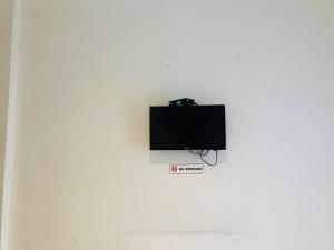 a flat screen tv on a white wall at Hotel Candra Kirana Syariah Prawirotaman Mitra RedDoorz in Yogyakarta