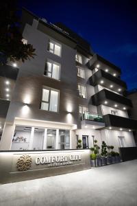 un edificio con un cartello che legge Città di Comfort di Comfort City Suites & Rooms a Larisa