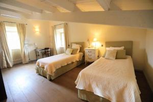 a bedroom with two beds and a table and window at Terrubi villa - piscine privee - tennis en provence verte in Le Val