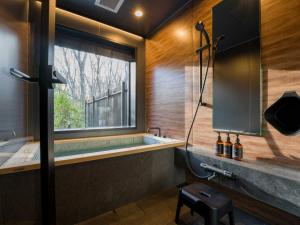 ein Bad mit einer Badewanne und einem großen Fenster in der Unterkunft Rakuten STAY VILLA Nasu Standard Family Room Capacity of 8 persons in Nasu