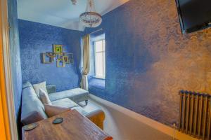 ein blaues Wohnzimmer mit einem Sofa und einem Tisch in der Unterkunft Plas Dolguog in Machynlleth