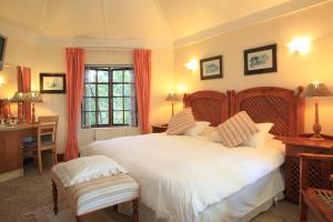 a bedroom with a large white bed and a desk at Mont Fleur B&B in Wilderness