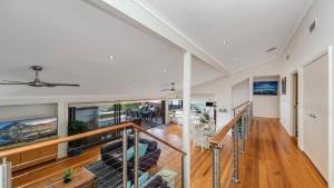 un grand salon avec un escalier et un plafond dans l'établissement The Inlet - Waterfront & Wifi, à Woy Woy
