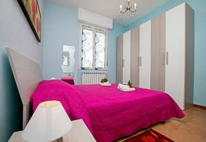a bedroom with a pink bed with a pink blanket at Villa Mimosa - Appartamento 1 - Happy Rentals in Desenzano del Garda