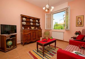 a living room with a tv and a table at Villa Mimosa - Appartamento 1 - Happy Rentals in Desenzano del Garda