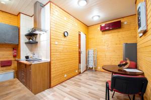 une chambre avec une table et une cuisine avec des murs en bois dans l'établissement Kauba 6-6 Apartment, à Kuressaare