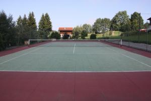 una pista de tenis con una casa en el fondo en Bon-Séjour, en Thollon-les-Mémises