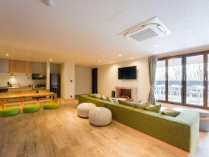 a living room with a green couch and a table at Rakuten STAY VILLA Nasu with open-air Jacuzzi Room Capacity of 8 persons in Nasu-yumoto