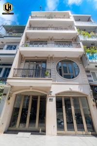 a tall white building with windows and a balcony at Luxury Condotel Sai Gon 2 in Ho Chi Minh City