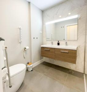 Un baño con lavabo, inodoro y espejo. en Vidorra sealine, en Torrox 21 fotos más