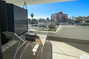 Un balcón con dos sillas y vista a una ciudad. en Vidorra sealine, en Torrox