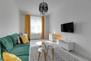 格但斯克的住宿－Primavera by Grand Apartments，客厅配有绿色沙发和电视