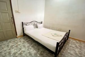 uma cama com lençóis brancos e almofadas num quarto em Hotel California Mitra RedDoorz em Pembunuh