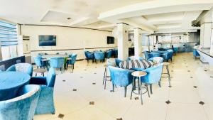 a dining room with blue chairs and tables at Panorama Amman Hotel in Amman