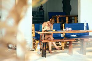 a woman sitting at a table at a table at Paradise Sunset Beach in Koh Rong Sanloem