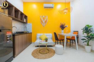 uma sala de estar com uma mesa e uma parede amarela em Luxury Condotel Sai Gon 2 em Cidade de Ho Chi Minh