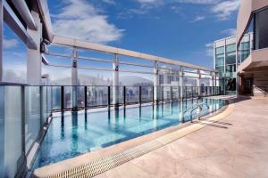 a swimming pool on the roof of a building at Nina Hotel Causeway Bay in Hong Kong