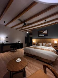 a large bedroom with a large bed and a desk at Eden Resort Nubra in Hundar