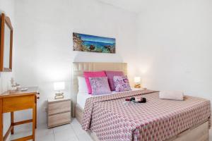 a bedroom with a bed with pink and purple pillows at Faro de Sardina Frente al Mar in Gáldar