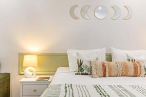 a bedroom with a large white bed with a bedside table at Tropic Retreat in Port Douglas