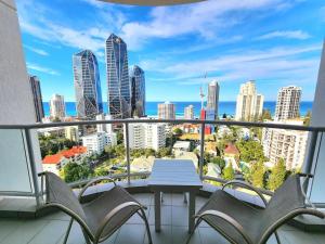 a balcony with a table and chairs and a city skyline at Deluxe Private Apartment and Studio - Ocean Views in Gold Coast