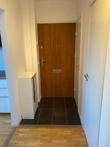 a hallway with a wooden door and a floor at Eurovision Finale 1BD in Malmö +1 photo