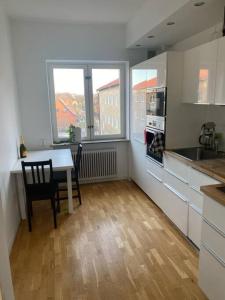 a kitchen with a table and a dining room with a window at Eurovision Finale 1BD in Malmö