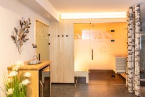 a bathroom with a shower and a wooden table at Frühstückshotel Birkenhof in Rauris +34 photos