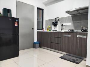 een keuken met een zwarte koelkast en een aanrecht bij M Vertica 3BR KL Cheras with Netflix in Kuala Lumpur