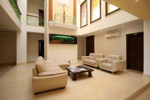 een grote woonkamer met banken en een televisie bij Collection O 8704 Hotel Sakshi in Gurgaon
