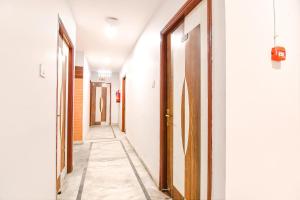 a hallway with white walls and wooden doors at FabExpress P3 in Ballygunge