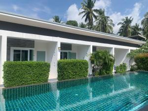 a swimming pool in front of a villa at Phangan Hometown Resort - Adults Only in Baan Tai