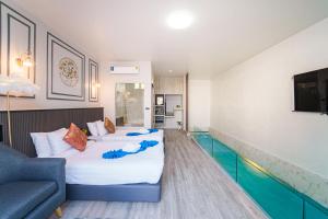 een hotelkamer met 2 bedden en een bank bij The Secret Garden Pool Villa Phuket in Ban Na Bon