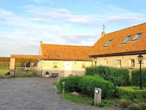 an old house with an orange roof and a driveway at B&B 't Hannonshof in Nieuwpoort