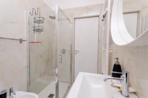 ein Bad mit einem Waschbecken und einer Dusche in der Unterkunft Delizioso Appartamento - A/C, Netflix e Balcone in Mailand