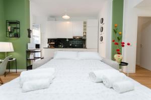 Cette chambre comprend un grand lit blanc et des murs verts. dans l'établissement Delizioso Appartamento - A/C, Netflix e Balcone, à Milan