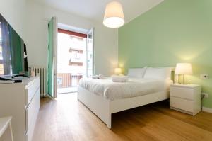 a white bedroom with a bed and a window at VivimiHome Fiordalisi a pochi passi dalla Metro in Milan
