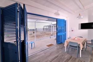 濱海塞利亞的住宿－Resort Giglio di Mare，一间设有桌子并享有海滩美景的用餐室