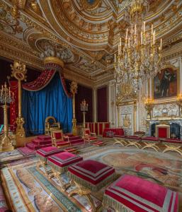 sala de estar con lámpara de araña y muebles de color rojo en The Empress Palace Hotel en Surrey