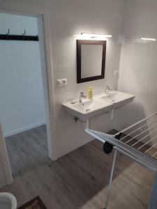 a bathroom with two sinks and a mirror at BÖJTÖS apartmány NESVADY in Nesvady