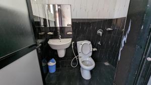 a bathroom with a toilet and a sink at Big John Hotel in Dehiwala